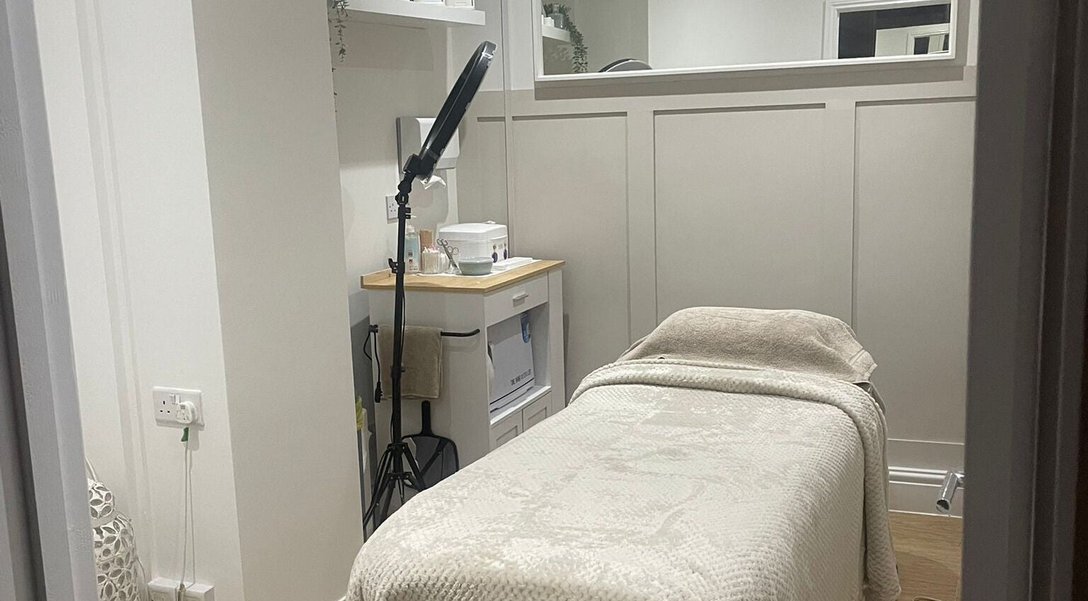 Tranquil treatment room at Harper Victoria Aesthetics, Bristol, England, GB with a cozy bed and soft lighting.