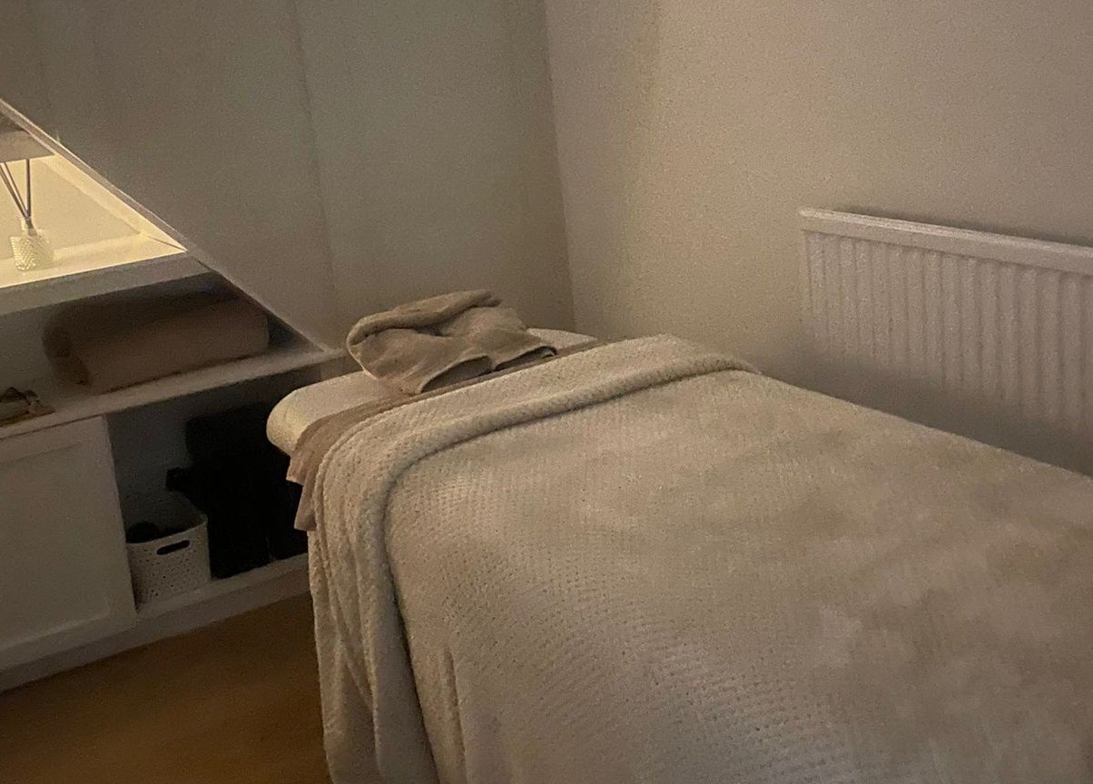 Relaxing treatment room at Harper Victoria Aesthetics, Bristol, England, GB, featuring a cozy massage bed.