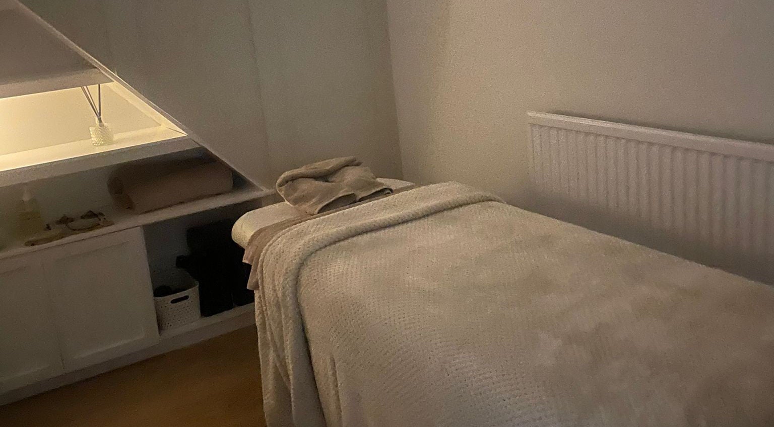 Relaxing treatment room at Harper Victoria Aesthetics, Bristol, England, GB, featuring a cozy massage bed.