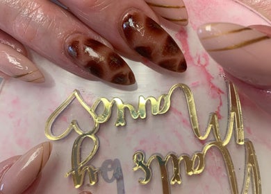 Stylish nail art design at Marie’s Nail Loft in Bonner Springs, Kansas, US showcasing elegant brown patterns.