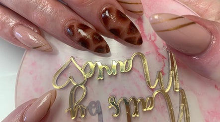 Stylish nail art design at Marie’s Nail Loft in Bonner Springs, Kansas, US showcasing elegant brown patterns.
