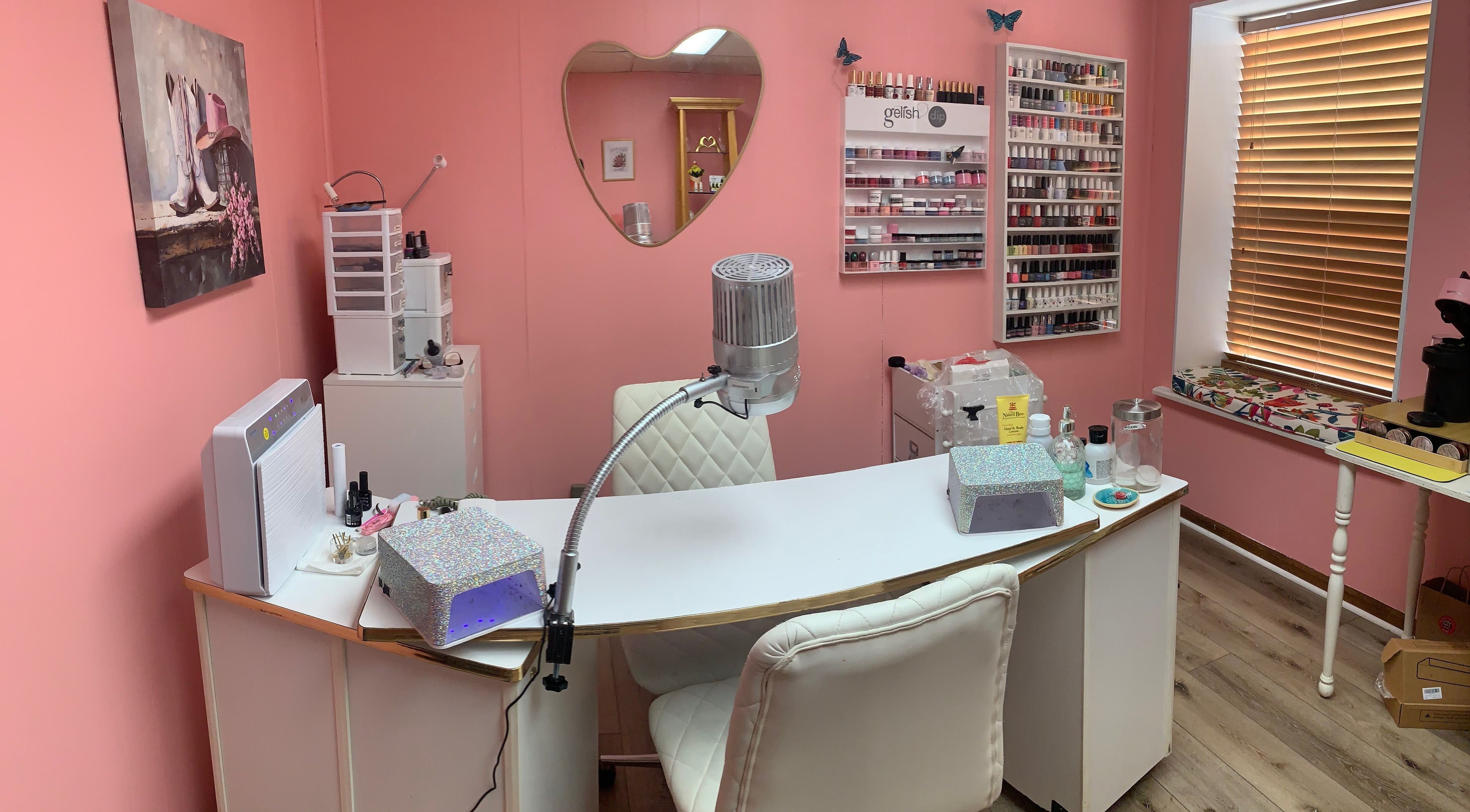 Cozy nail station at Marie’s Nail Loft in Bonner Springs, Kansas, US with pink decor and multiple polish options.