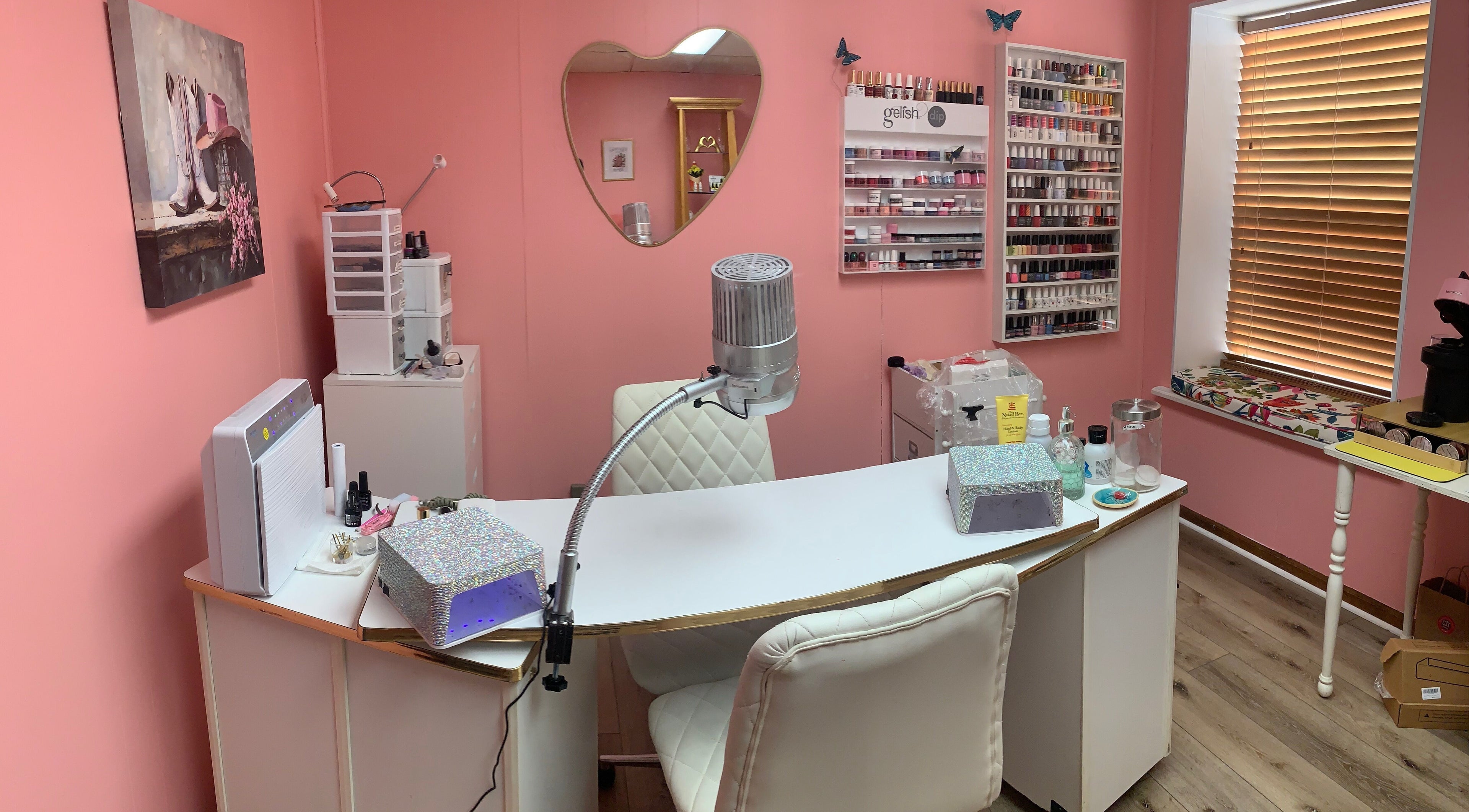 Cozy nail station at Marie’s Nail Loft in Bonner Springs, Kansas, US with pink decor and multiple polish options.