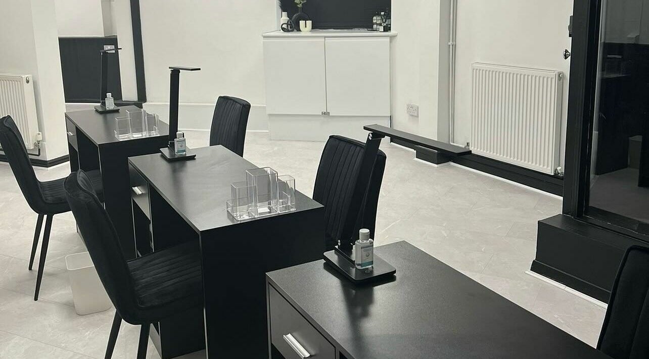 Modern nail stations at Glo Hair and Beauty, Coventry, England, GB, showcasing sleek black furnishings.