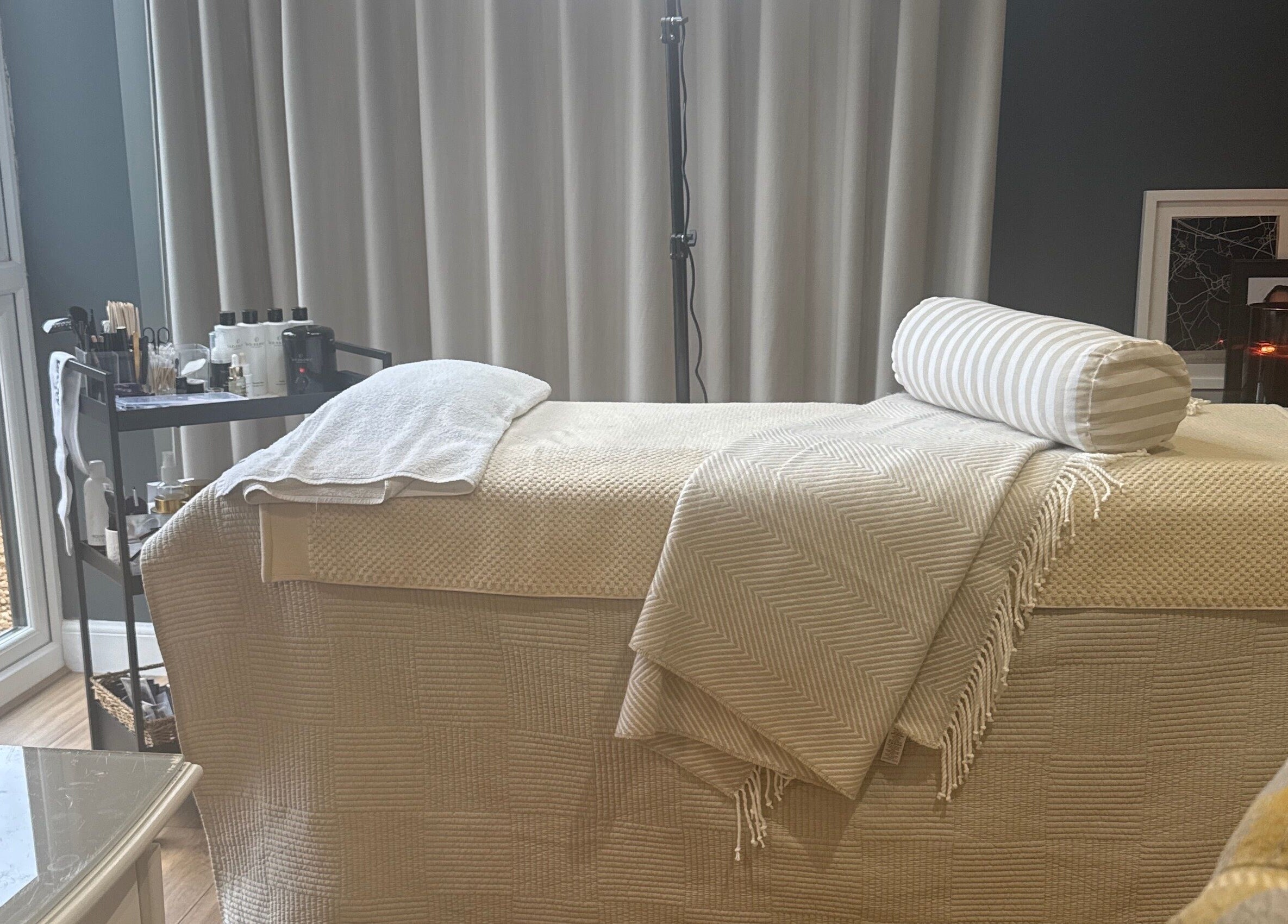 Relaxing treatment room at Brows By Jenna, Northampton, England, GB with cozy massage bed and elegant decor.