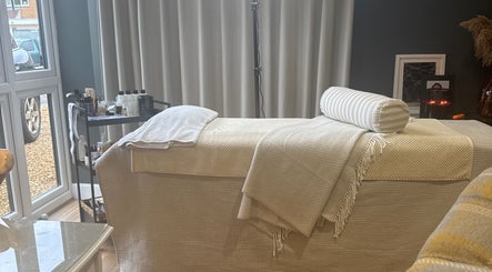 Relaxing treatment room at Brows By Jenna, Northampton, England, GB with cozy massage bed and elegant decor.