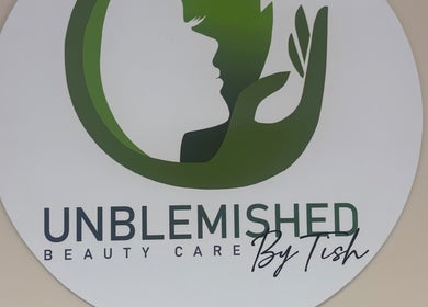 Unblemished By Tish (Anguilla) logo on wall, US location, highlighting beauty care services.