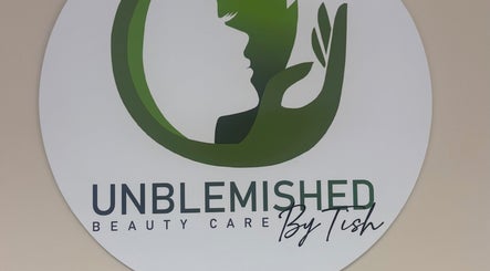 Unblemished By Tish (Anguilla) logo on wall, US location, highlighting beauty care services.