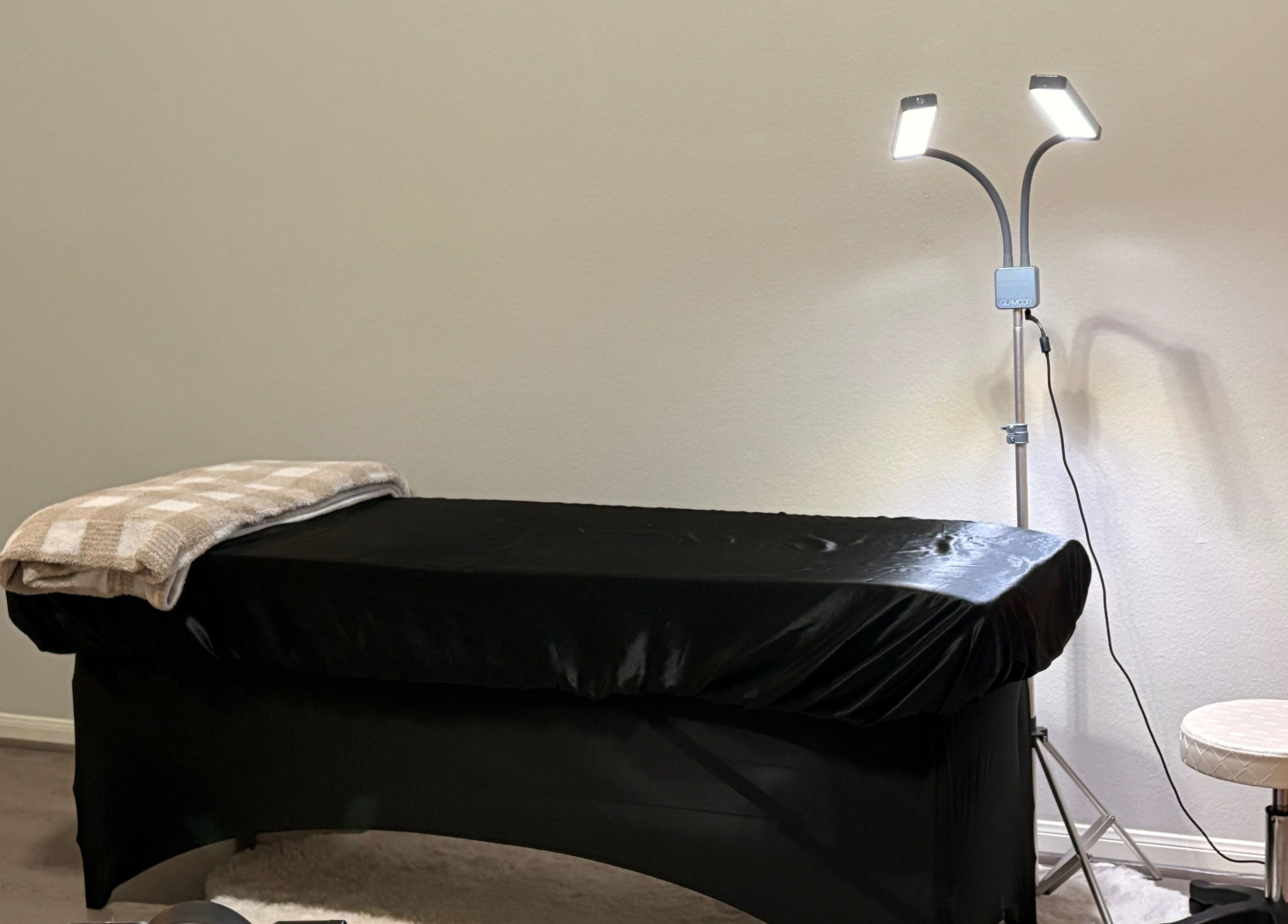 Elegant treatment room at Elegance Studio in Houston, Texas, US, featuring a cozy massage table and soft lighting.