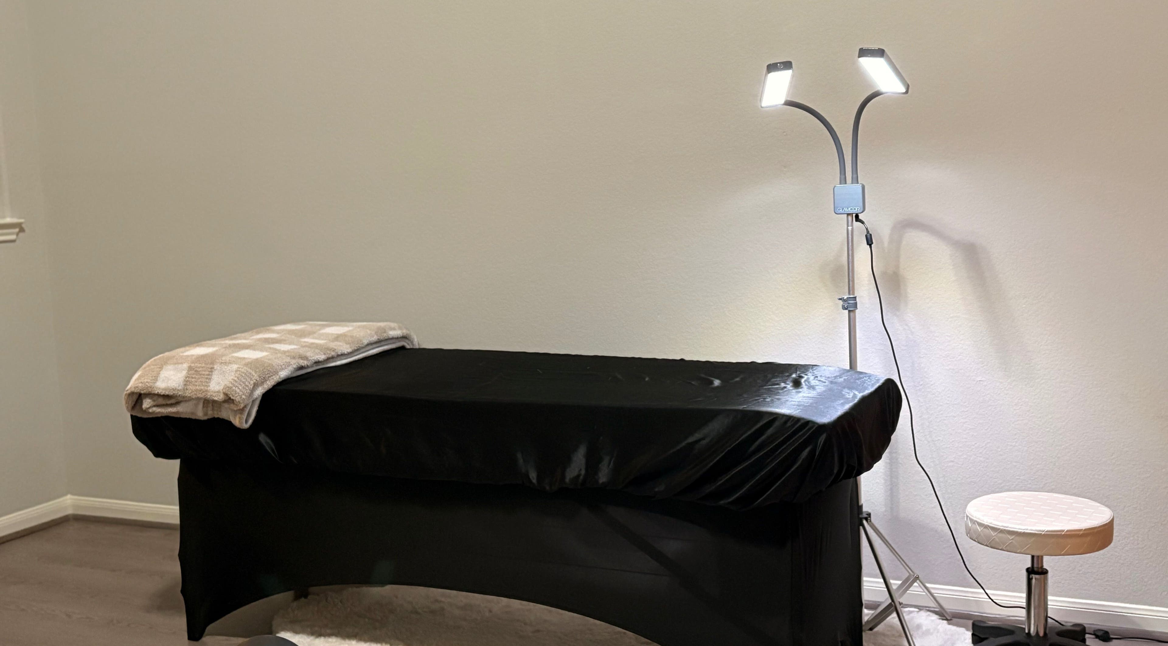 Elegant treatment room at Elegance Studio in Houston, Texas, US, featuring a cozy massage table and soft lighting.