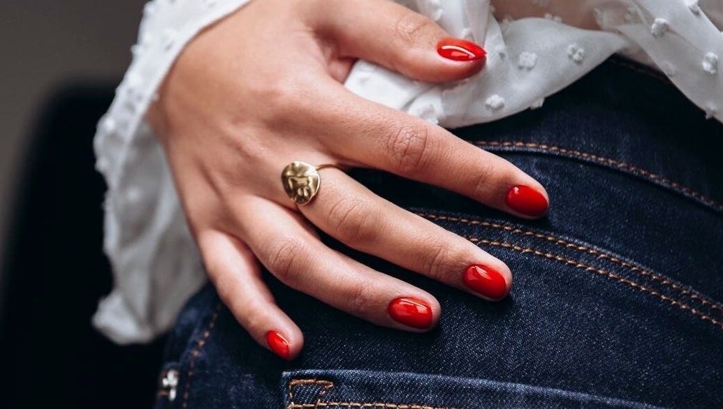 Main avec ongles rouge chic à Chloé Buire Salon de Beauté & Académie, Saint Philipe, Québec, CA.