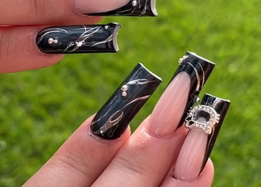 Stylish black and nude nail art with rhinestones at Demi.DidThem, Port St. Lucie, Florida, US.