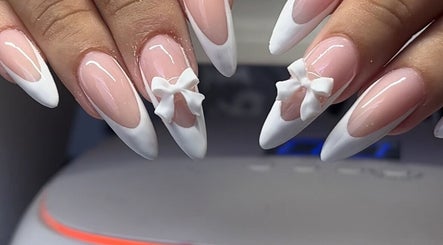 Elegant french-tipped nails with 3D bows at Demi.DidThem, Port St. Lucie, Florida, US.
