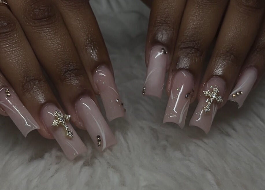 Stylish pink nails with cross design at Demi.DidThem in Port St. Lucie, Florida, US.