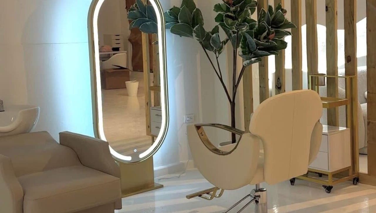 Silla moderna y espejo iluminado en RJ Studio, San Sebastián, San Sebastián, PR.