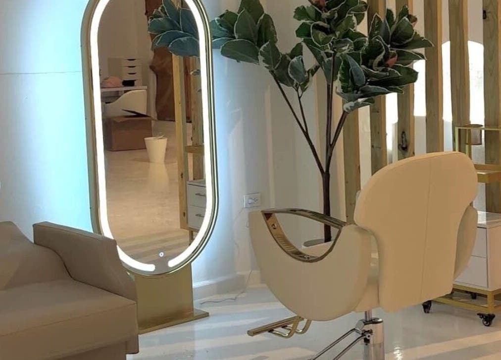 Silla moderna y espejo iluminado en RJ Studio, San Sebastián, San Sebastián, PR.