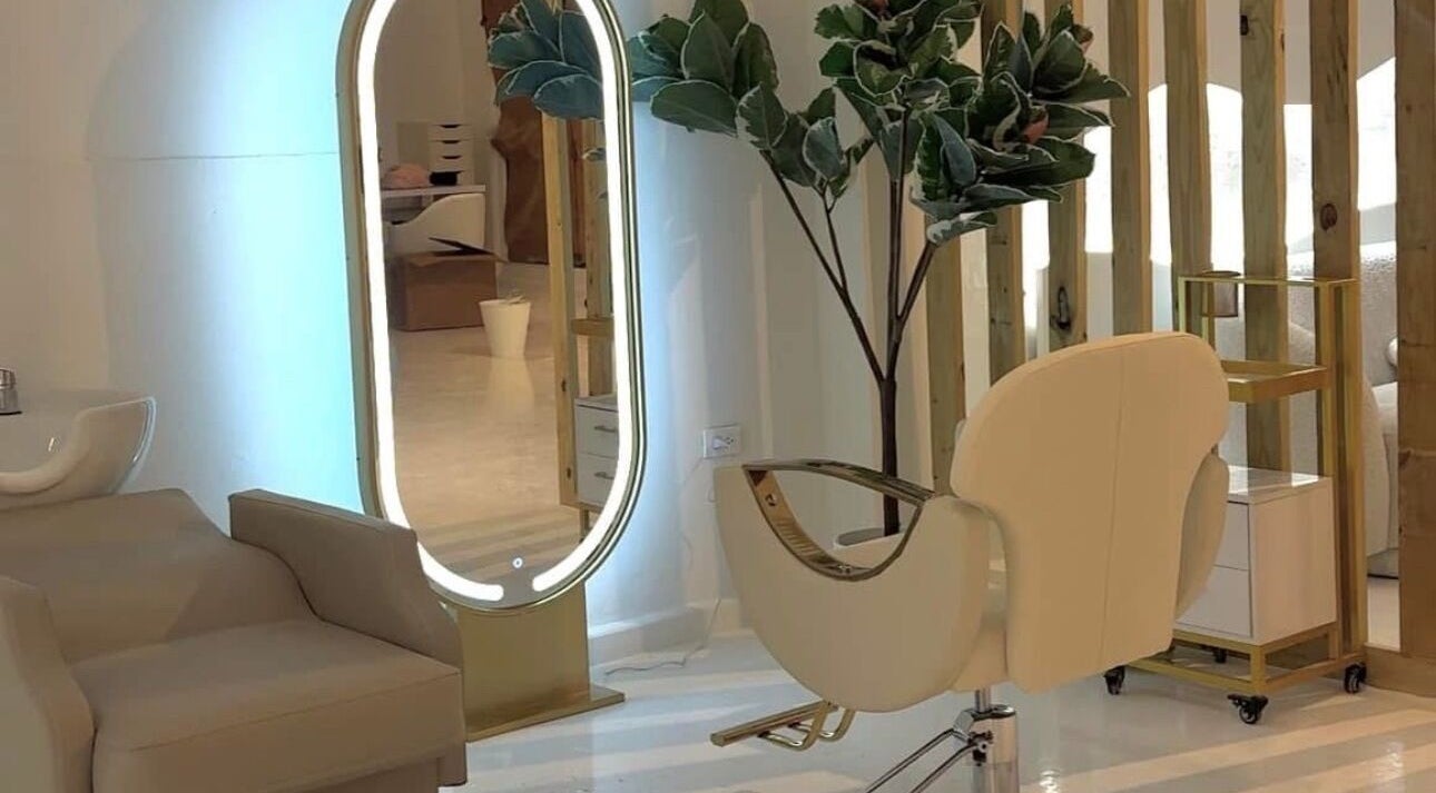 Silla moderna y espejo iluminado en RJ Studio, San Sebastián, San Sebastián, PR.