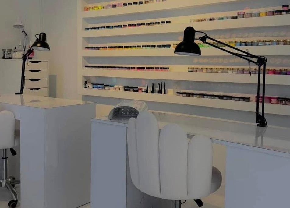 Interior moderno de RJ Studio en San Sebastián, PR, mostrando estación de manicura con herramientas y esmaltes.