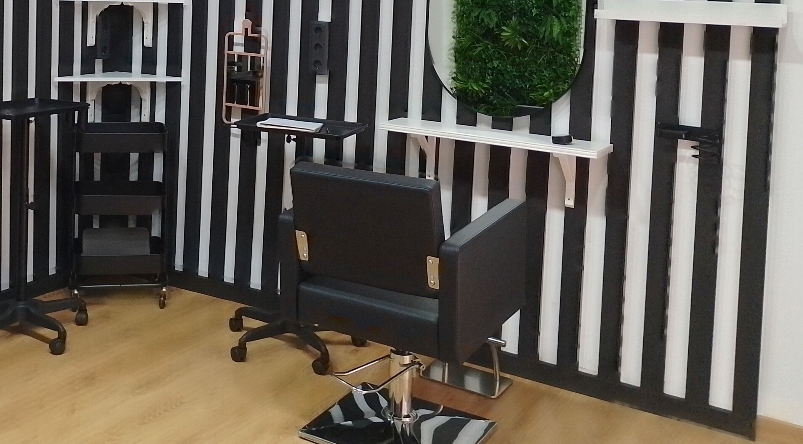 Silla moderna en FOLK Hair Salon, Barcelona, Catalunya, ES, con pared de rayas en blanco y negro.