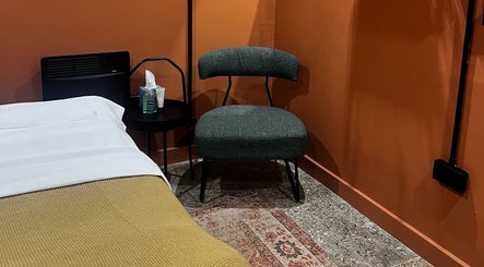 Cozy therapy room at Skin & Dosha South Bank Studio, London, England, GB with a comfy chair and treatment table.