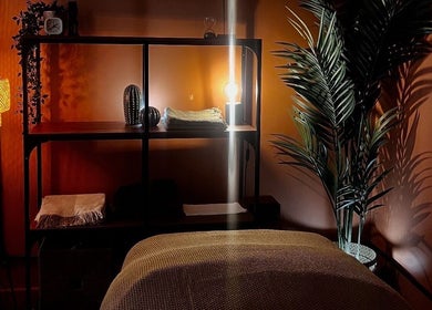 Warm, ambient spa room at Skin & Dosha South Bank Studio, London, England, GB, featuring soft lighting and a massage bed.