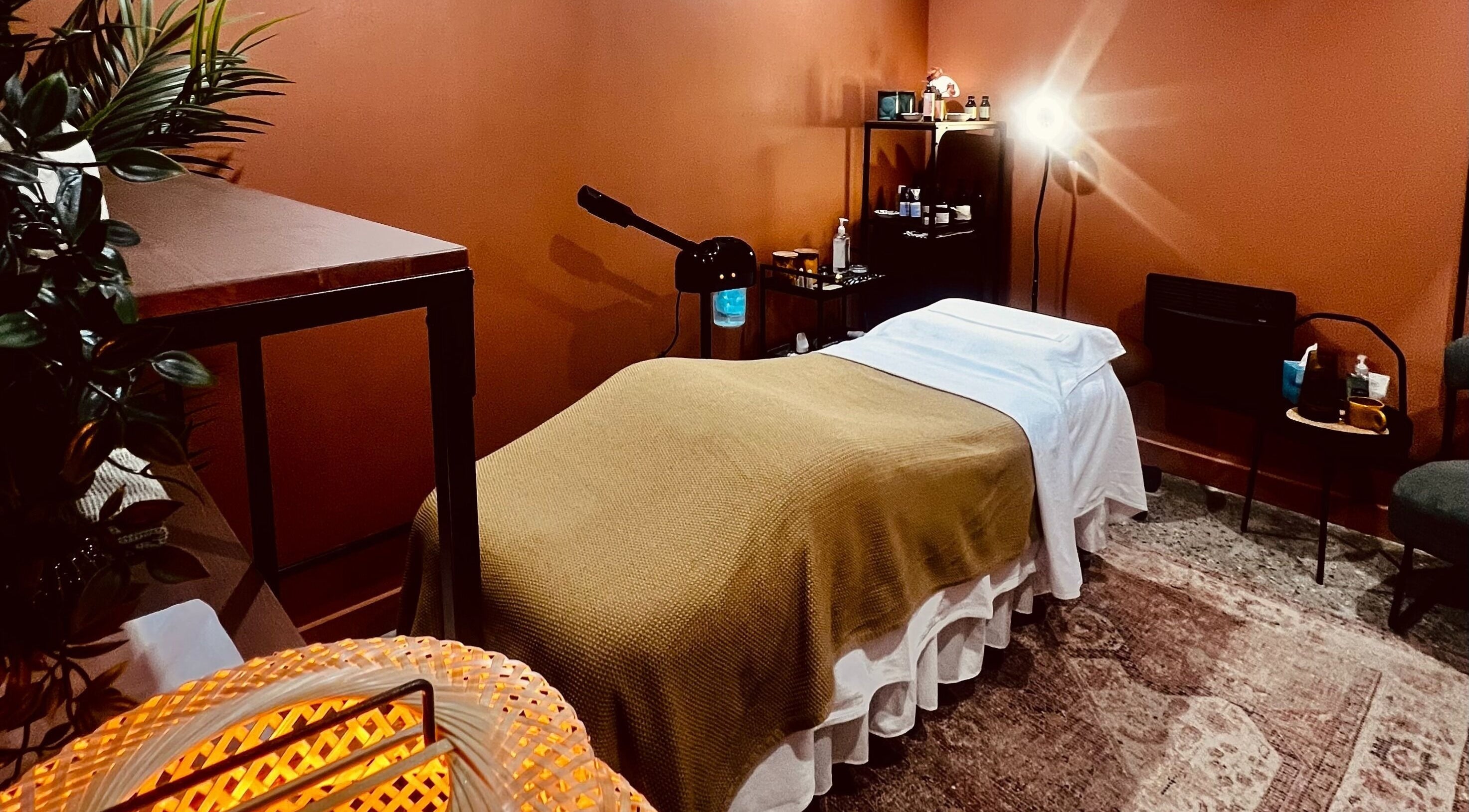 Cozy treatment room at Skin & Dosha Southwark SE1 Studio, London, England, GB with earthy tones and ambient lighting.