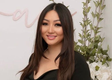 Staff member at Grace Brows & Beauty, Penrith, New South Wales, AU, with welcoming smile and floral decor.
