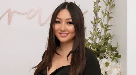 Staff member at Grace Brows & Beauty, Penrith, New South Wales, AU, with welcoming smile and floral decor.