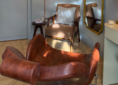 Cozy seating area at Peaches & Pearls Studio, Dundee, Scotland, GB with brown chairs and ambient lighting.