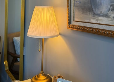 Warmly lit lamp and ornate framed art in Peaches & Pearls Studio, Dundee, Scotland, GB.