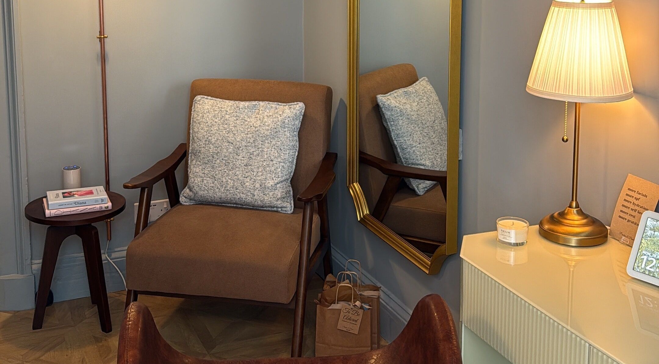 Elegant seating area at Peaches & Pearls Studio, Dundee, Scotland, GB, featuring a brown armchair and gold lamp.