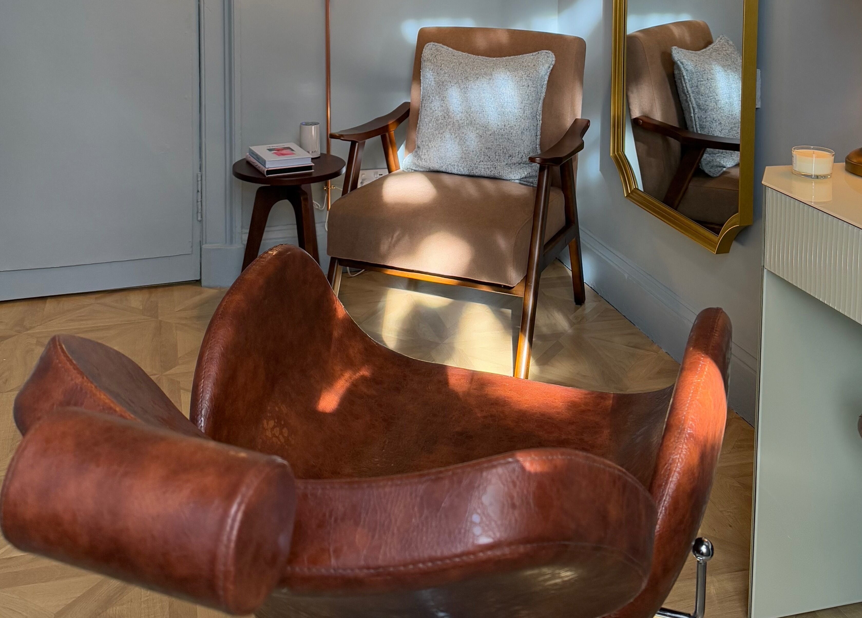 Elegant chair and mirror at Peaches & Pearls Studio, Dundee, Scotland, GB, creating a warm, inviting ambiance.