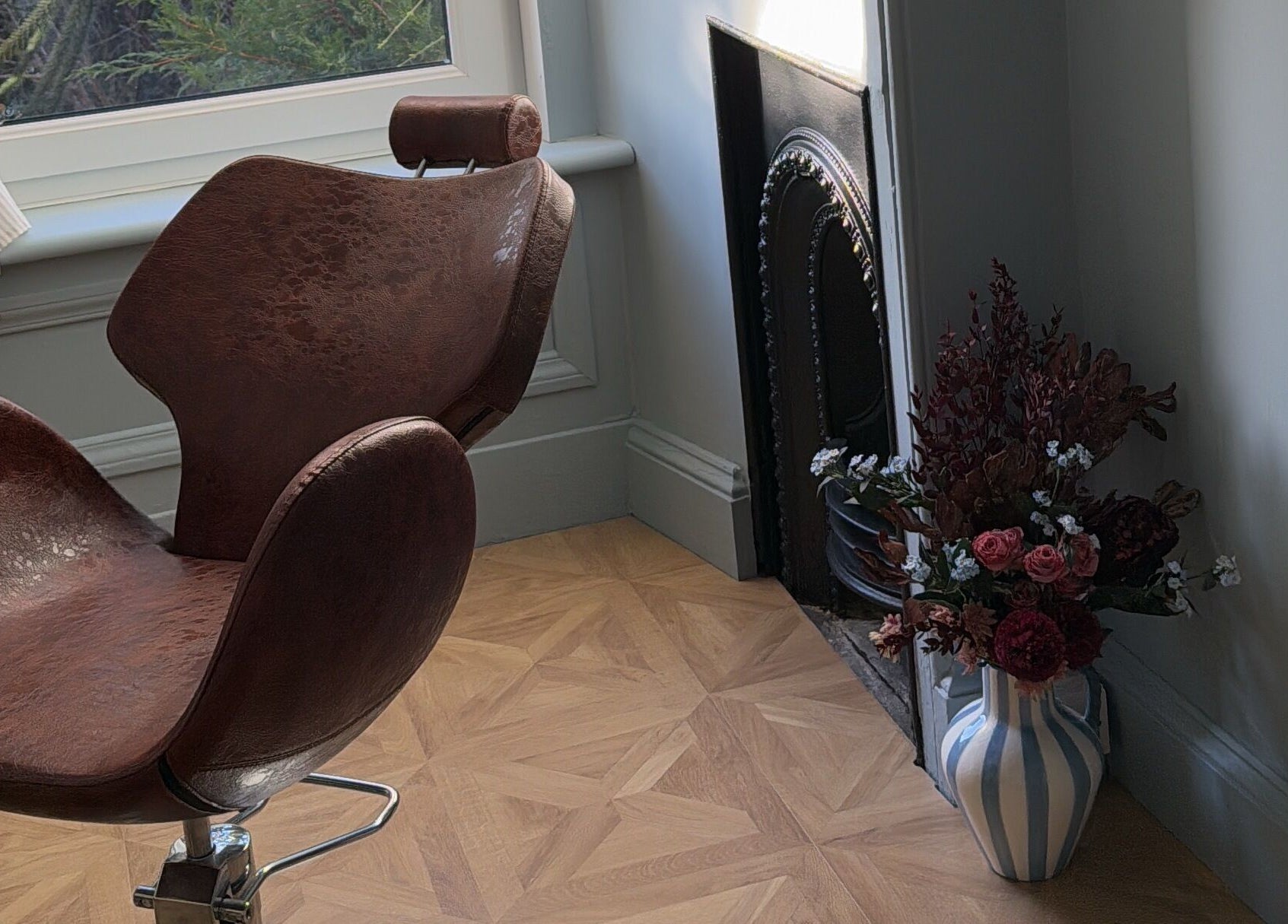 Elegant salon chair and floral vase at Peaches & Pearls Studio, Dundee, Scotland, GB.