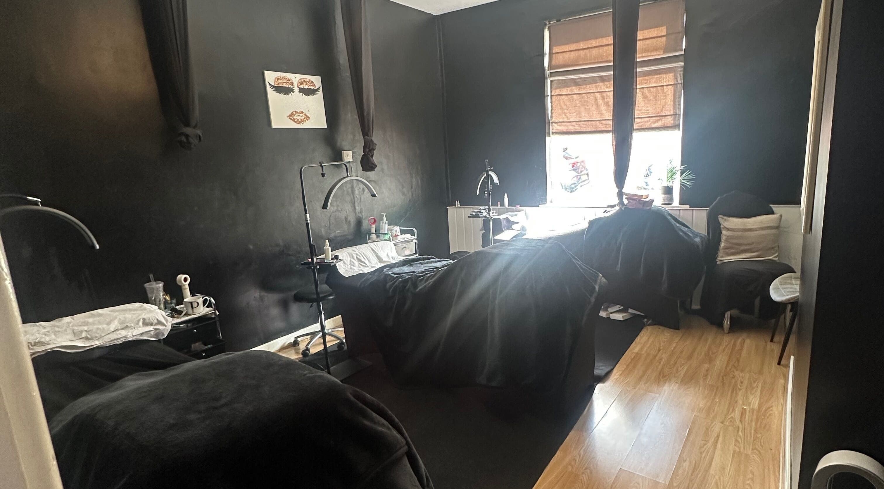 Cozy treatment room at Haru Beauty (Salon base), Wigan, England, GB, with black walls and wooden floor.