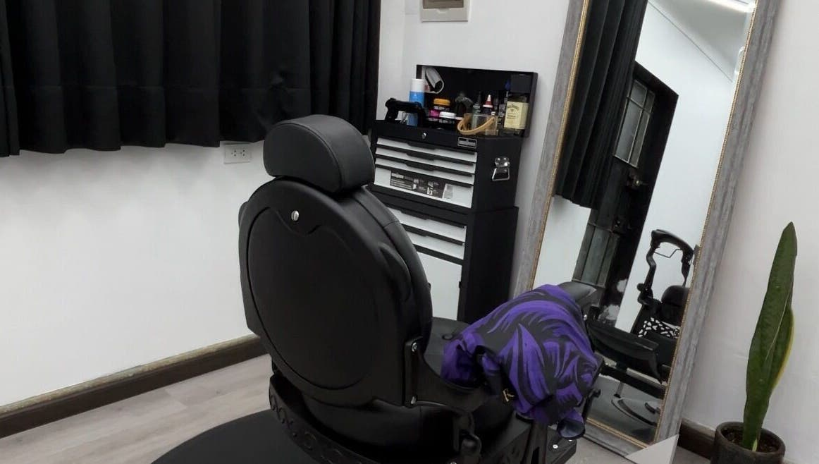 Sala elegante en Ryuk Barber, Chimbote, Áncash, PE, con silla negra y espejo grande.
