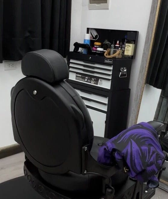 Sala elegante en Ryuk Barber, Chimbote, Áncash, PE, con silla negra y espejo grande.