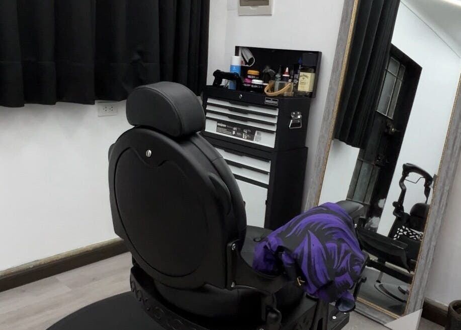 Interior moderno de Ryuk Barber en Chimbote, Áncash, PE con silla de peluquería y espejo amplio.