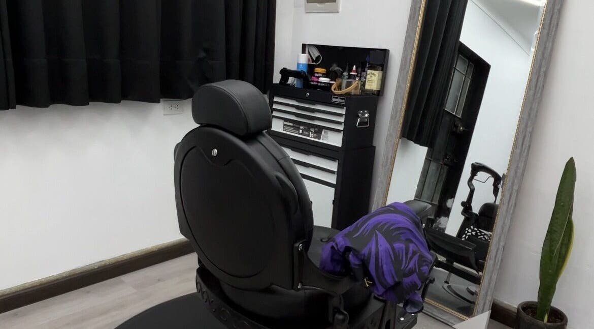 Interior moderno de Ryuk Barber en Chimbote, Áncash, PE con silla de peluquería y espejo amplio.