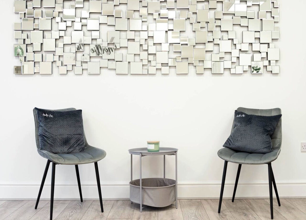 Modern seating area with artistic mirror in Mollie Elise Aesthetics, Chorley, England, GB.