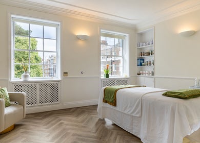 Bright therapy room at Rose Beauty Clinic, London, England, GB, with massage bed and soft lighting.