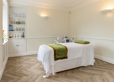 Calming treatment room at Rose Beauty Clinic in London, England, GB with a neatly arranged massage table.