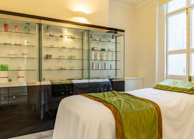 Serene spa room at Rose Beauty Clinic, London, England, GB showcasing a cozy treatment bed and elegant shelves.