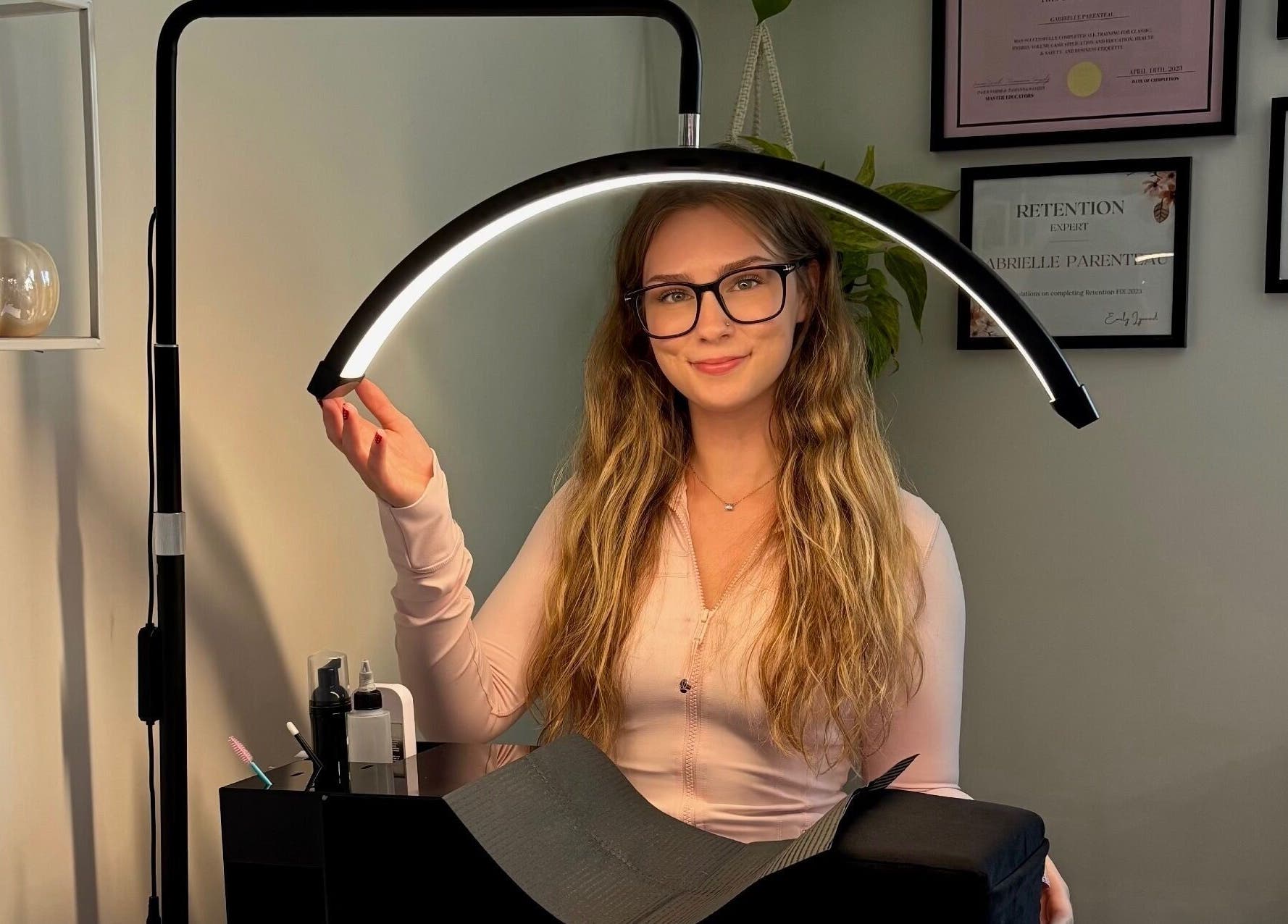 Lash artist at Lunaria Lash Loft in Barrie, Ontario, CA, preparing workspace with a lighting setup.