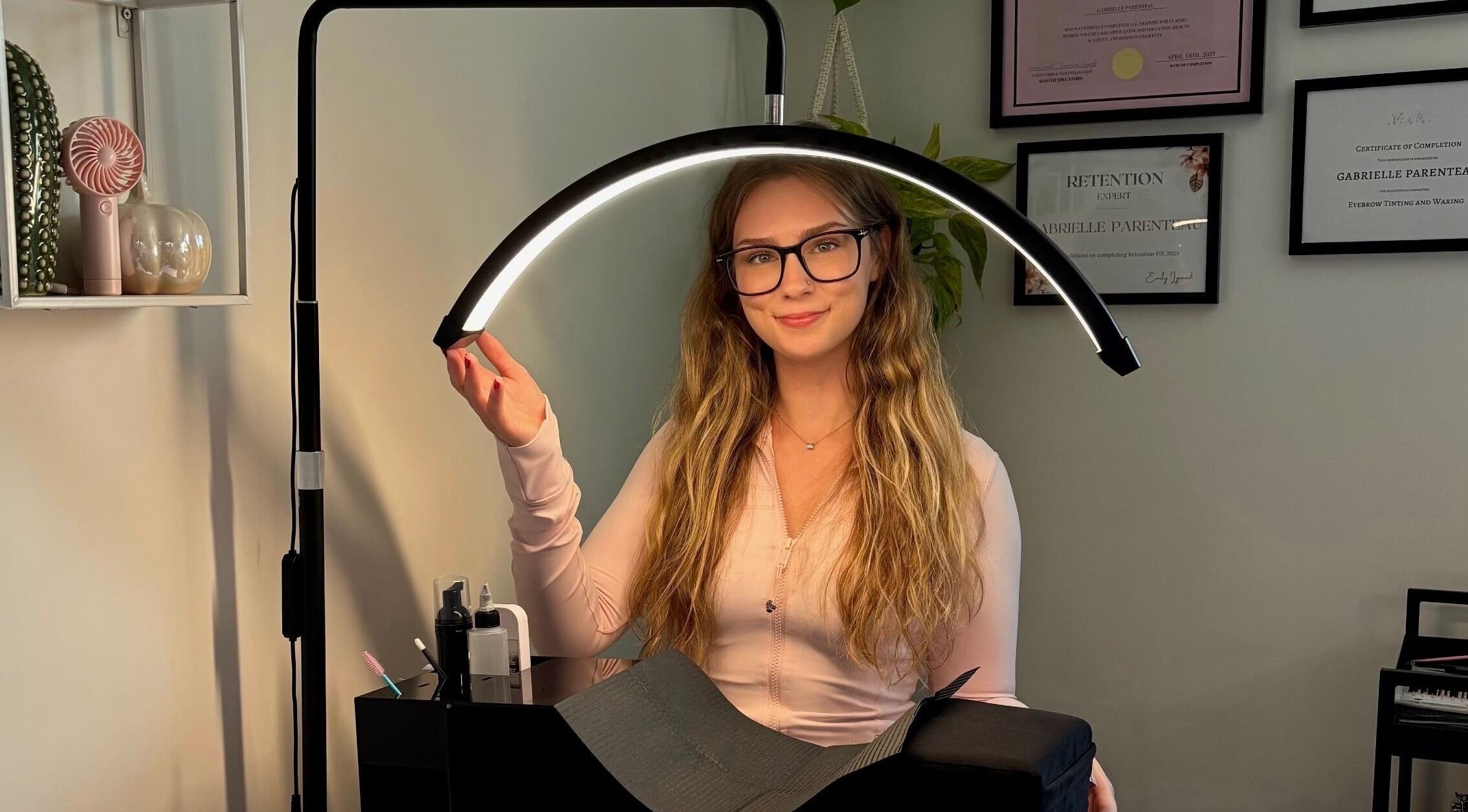 Lash artist at Lunaria Lash Loft in Barrie, Ontario, CA, preparing workspace with a lighting setup.