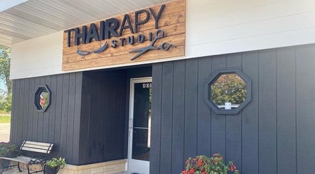 Entrance of T'Hairapy Studio with a modern wooden sign in Kenosha, Wisconsin, US.
