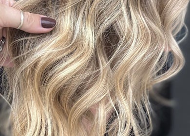 Elegant blonde wavy hair showcased at T'Hairapy Studio in Kenosha, Wisconsin, US.