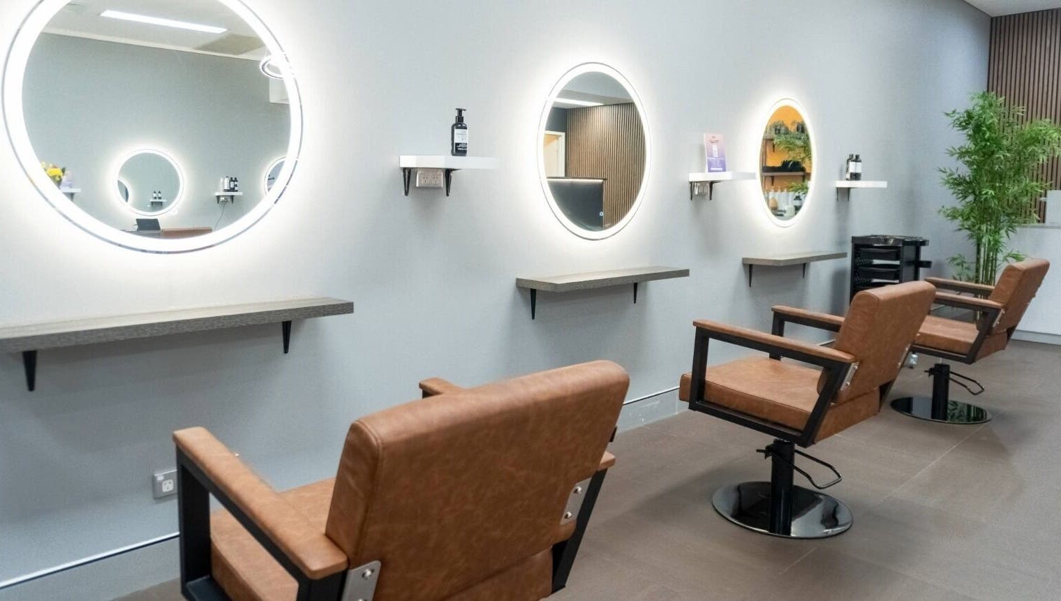 Modern salon interior at Cuts By Carella, Cairns City, Queensland, AU featuring stylish chairs and mirrors.
