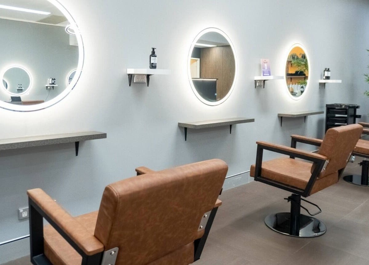 Modern salon interior at Cuts By Carella, Cairns City, Queensland, AU featuring stylish chairs and mirrors.