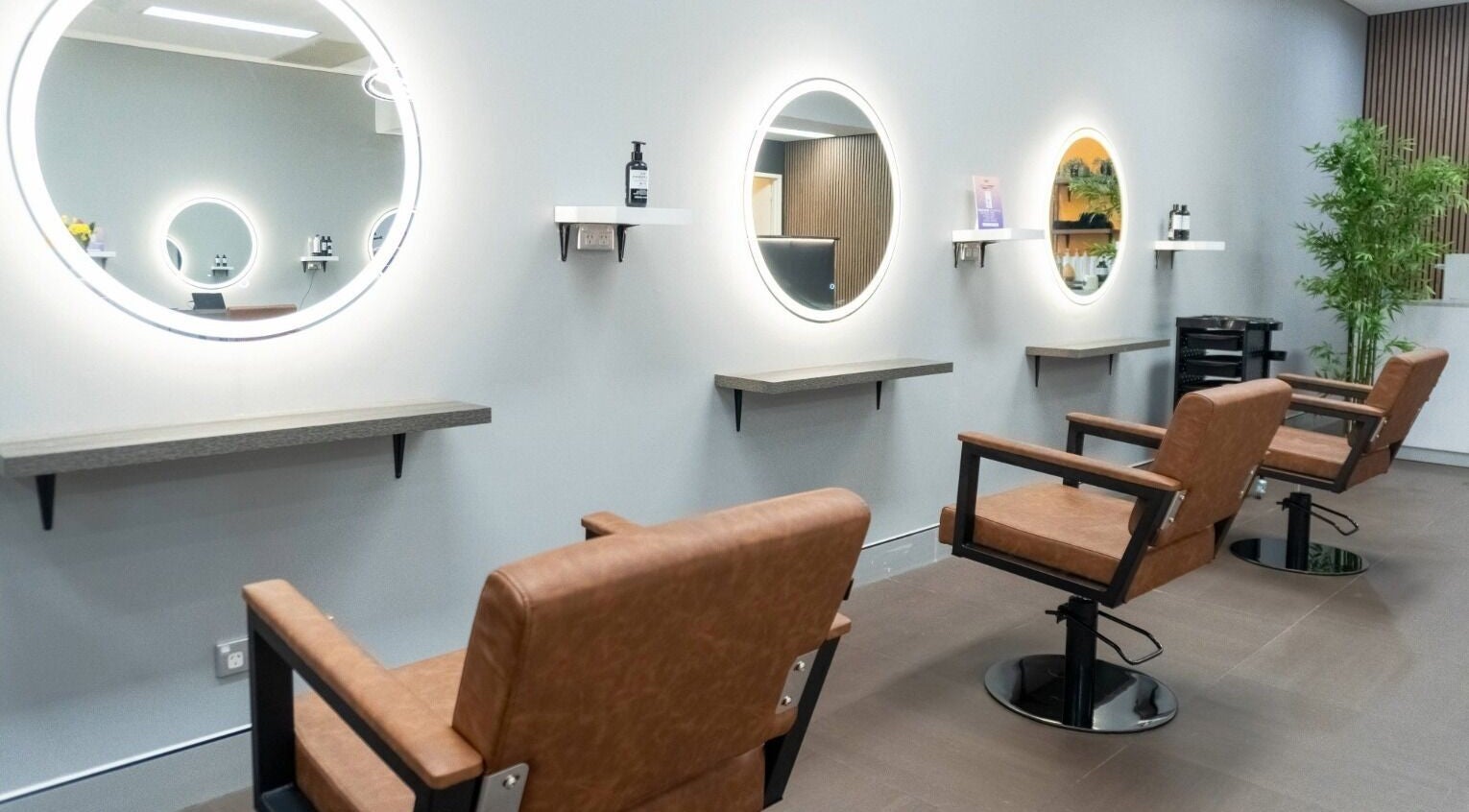 Modern salon interior at Cuts By Carella, Cairns City, Queensland, AU featuring stylish chairs and mirrors.