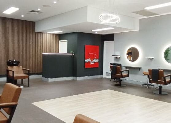 Modern interior of Cuts By Carella, Cairns City, Queensland, AU, featuring stylish chairs and illuminated mirrors.